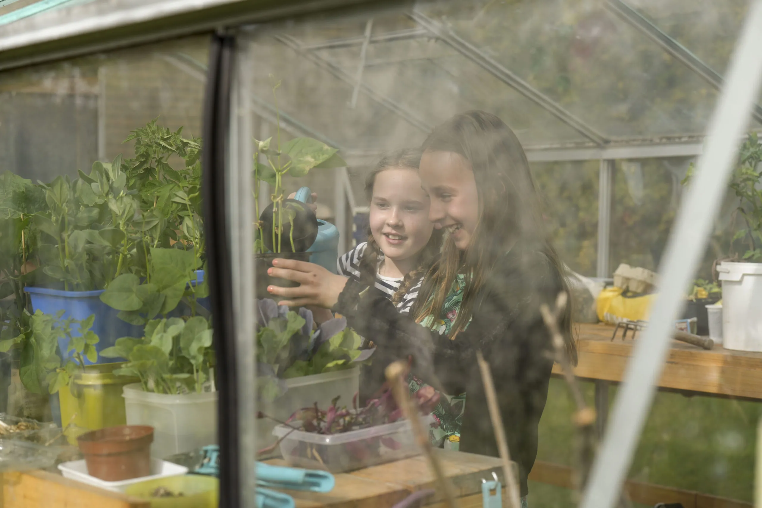 Twee meiden die aan het tuinieren zijn tijdens een activiteit van Happyfit