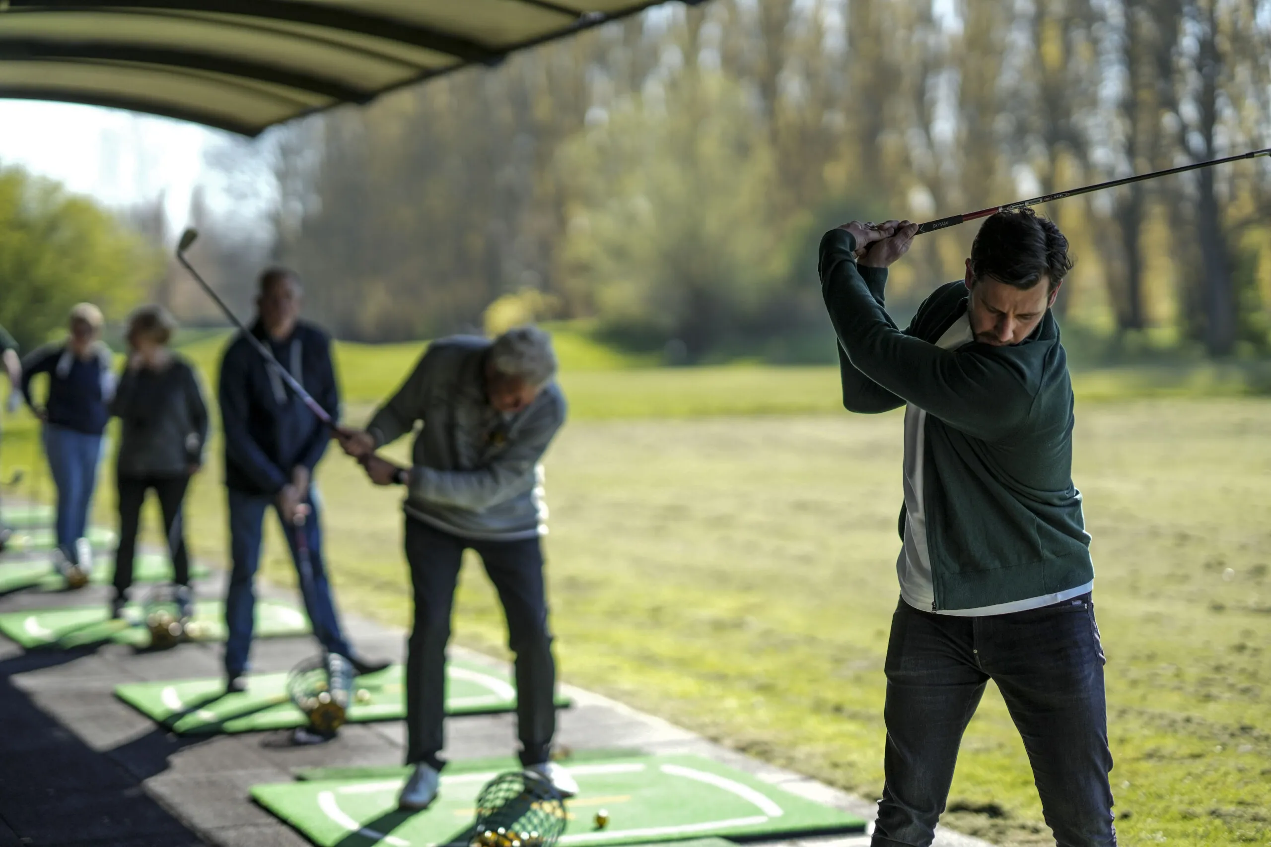Mannen die aan het afslaan zijn op de golfbaan