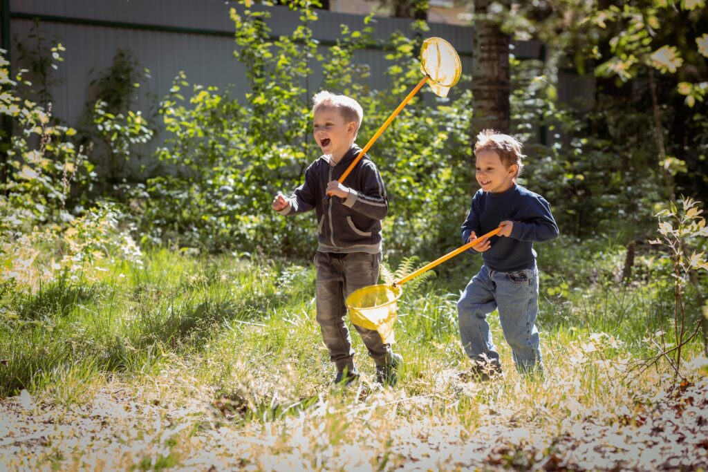 Kinderen die rondrennen door de natuur met een schepnetje in hun handen